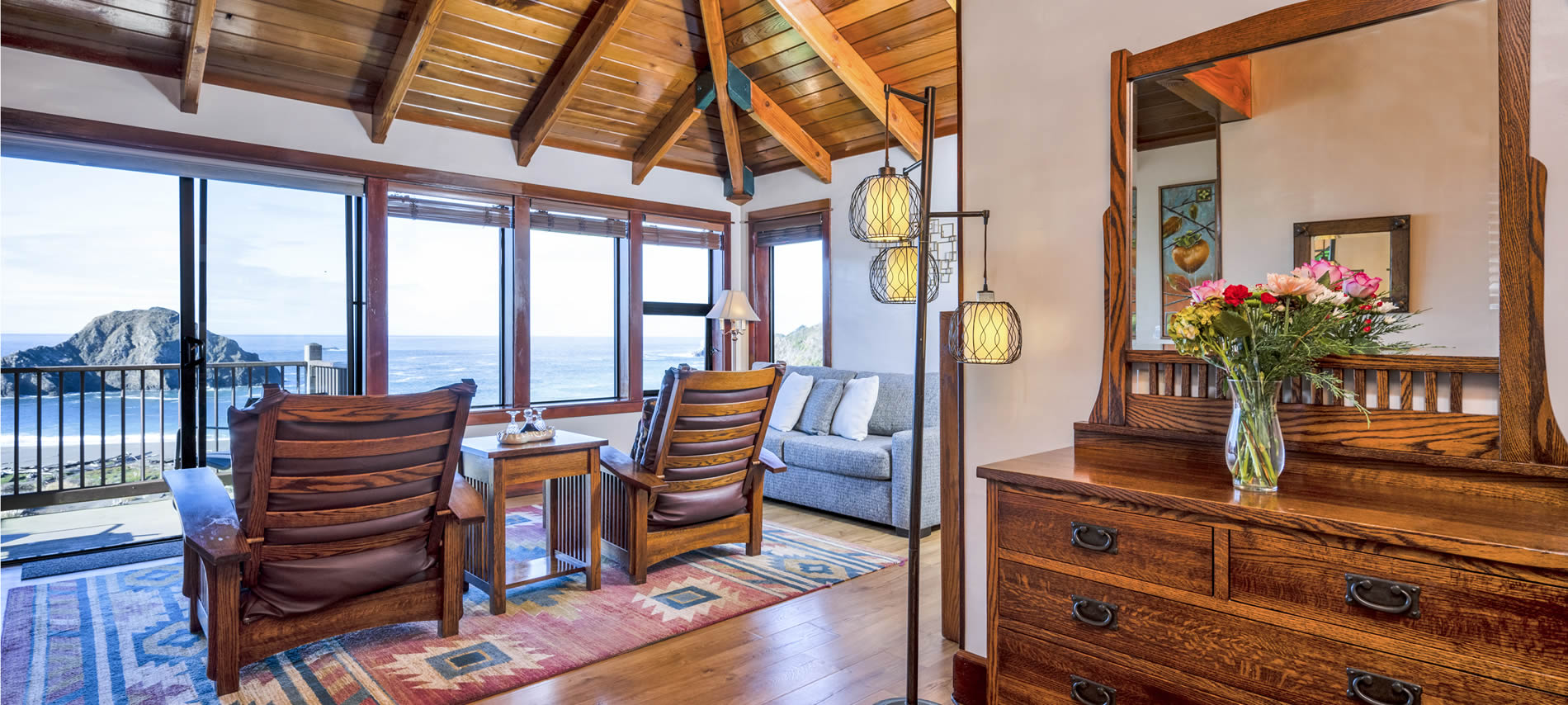 oceanview guest room with chairs, couch and dresser